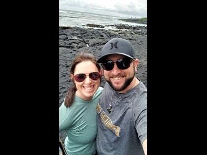 Happy couple taking at selfie at Punalu'u Black Sand Beach in Hawaii while on vacation with Hilton Grand Vacations.