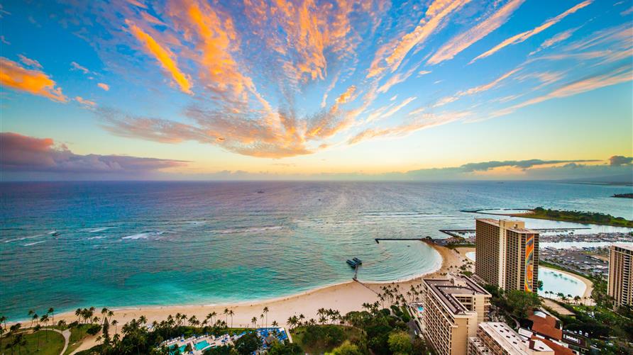 Painted skies overhead Hilton Grand Vacations Hawaii resorts and Hilton Hawaiian Village in Oahu, Hawaii.