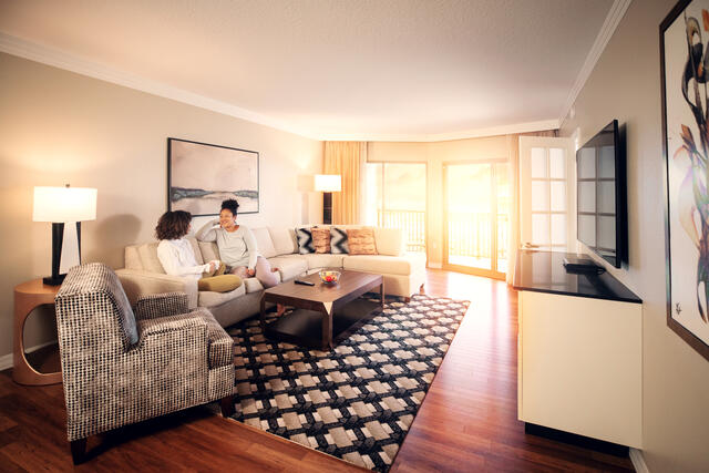 Teen and mature women chatting while sitting on the couch in the living room at Parc Soleil by Hilton Grand Vacations in Orlando, Florida.