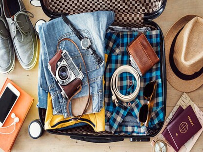 Overhead shot of a man's suitcase preparing to travel. 