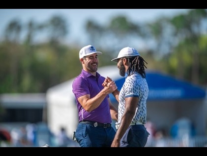Celebrities at Hilton Grand Vacations Tournament of Champions smiling and giving fist bump on the green.