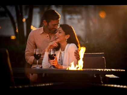 Couple enjoying glass of wine and fire pit at HIlton Grand Vacations Orlando resort. 