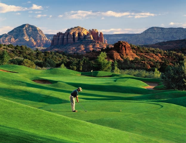 Stunning panorama of man golfing on sprawling course with a Red Rock Country backdrop, Hilton Sedona Resort at Bell Rock, Airzona. 