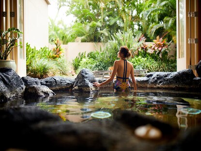 Woman admiring the lush scenery from the hot tub at Kohala Spa, Hilton Waikoloa Village®, Big Island, Hawaii.
