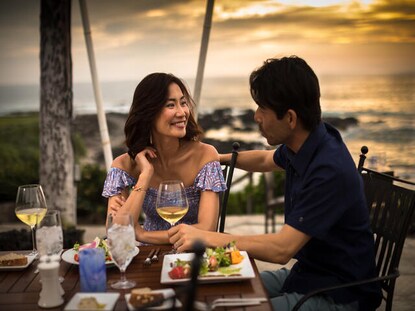 Couple dining alfresco at sunset at Kings' Land, a Hilton Grand Vacations Club, Big Island, Hawaii.