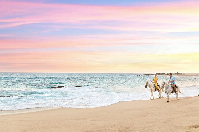 Couple horseback riding along a Los Cabos beach, La Pacifica Los Cabos, a Hilton Club, Mexico.