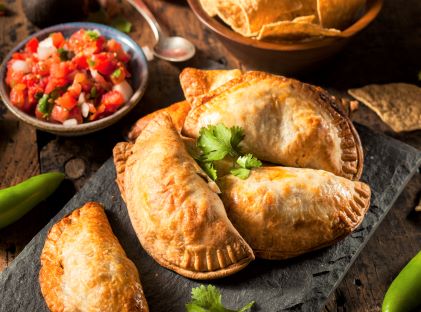 A pile of empanadas on a plate, similar to the ones found in Miami, Florida's Little Havana, a Cuban neighborhood